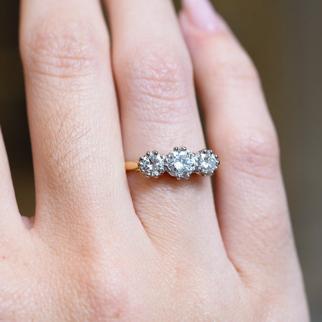 Antique Art Deco diamond three-stone ring with graduated diamond setting and yellow gold band.
