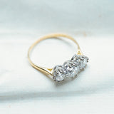 Antique Art Deco diamond three-stone ring with raised diamond setting and fine gold band.