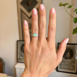 Antique Art Deco opal and diamond cluster ring worn on hand, showcasing a glowing opal centre stone flanked by diamonds on either side.
