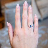 Antique Belle Époque sapphire and diamond cluster engagement ring worn on hand.