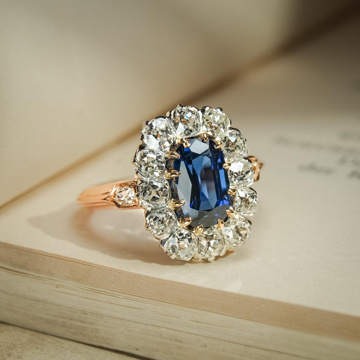 Antique blue sapphire cluster ring with diamond halo surround