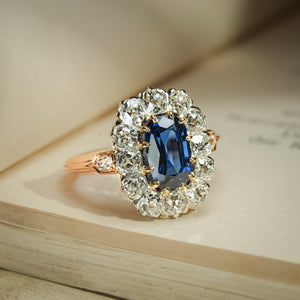 Antique blue sapphire cluster ring with diamond halo surround