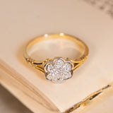 Antique daisy cluster ring showcasing a flower-shaped arrangement of old-cut diamonds with elegant detailing and a slender yellow gold band.