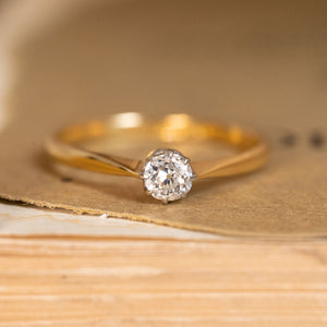 Antique Edwardian diamond solitaire engagement ring featuring an old-cut diamond in a delicate yellow gold setting with platinum-topped claws.