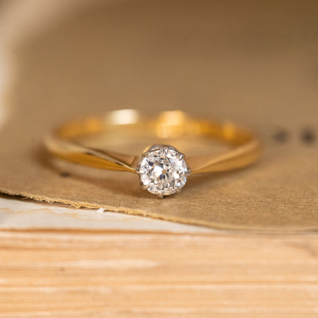 Antique Edwardian diamond solitaire engagement ring featuring an old-cut diamond in a delicate yellow gold setting with platinum-topped claws.