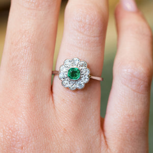 Antique Edwardian emerald and old-mine cut diamond cluster ring with vivid green emerald centre stone and diamond halo.
