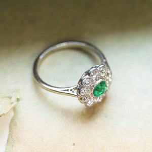 Antique Edwardian emerald and old-mine cut diamond cluster ring with floral cluster design and bright green emerald centre.