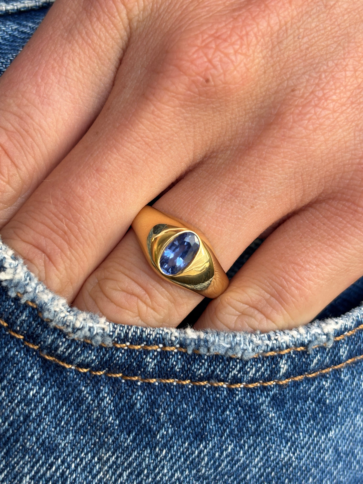Antique Edwardian iris-blue sapphire gypsy engagement ring with an iris-blue sapphire centre stone in a traditional gypsy setting, worn on a hand.
