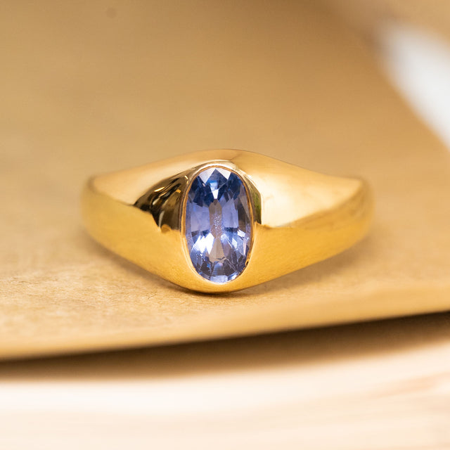 Antique Edwardian gypsy ring featuring an iris-blue sapphire flush-set within a yellow gold band.