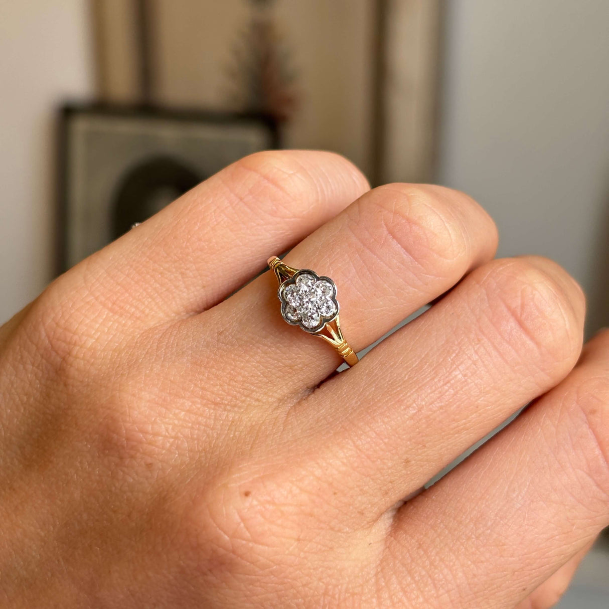 Close-up of an antique Edwardian old-cut diamond daisy cluster ring featuring a brilliant old-cut diamond centre stone framed by a diamond daisy halo.