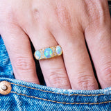 Antique Edwardian opal and diamond three-stone ring styled with denim pocket.