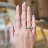 Antique Edwardian opal and diamond three-stone ring worn on hand.
