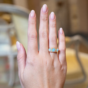 Antique Edwardian opal and diamond three-stone ring worn on hand.
