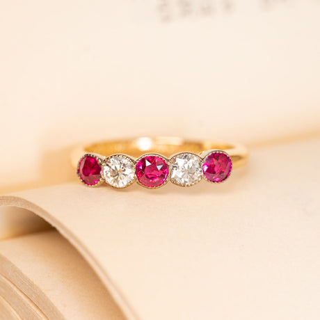 Antique Edwardian five-stone ring featuring vibrant rubies alternating with sparkling old-cut diamonds in a classic yellow gold setting.