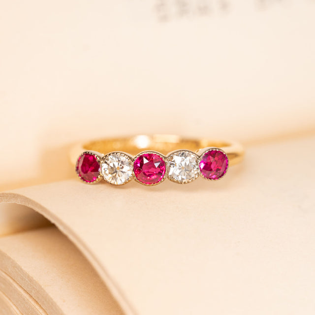 Antique Edwardian five-stone ring featuring vibrant rubies alternating with sparkling old-cut diamonds in a classic yellow gold setting.