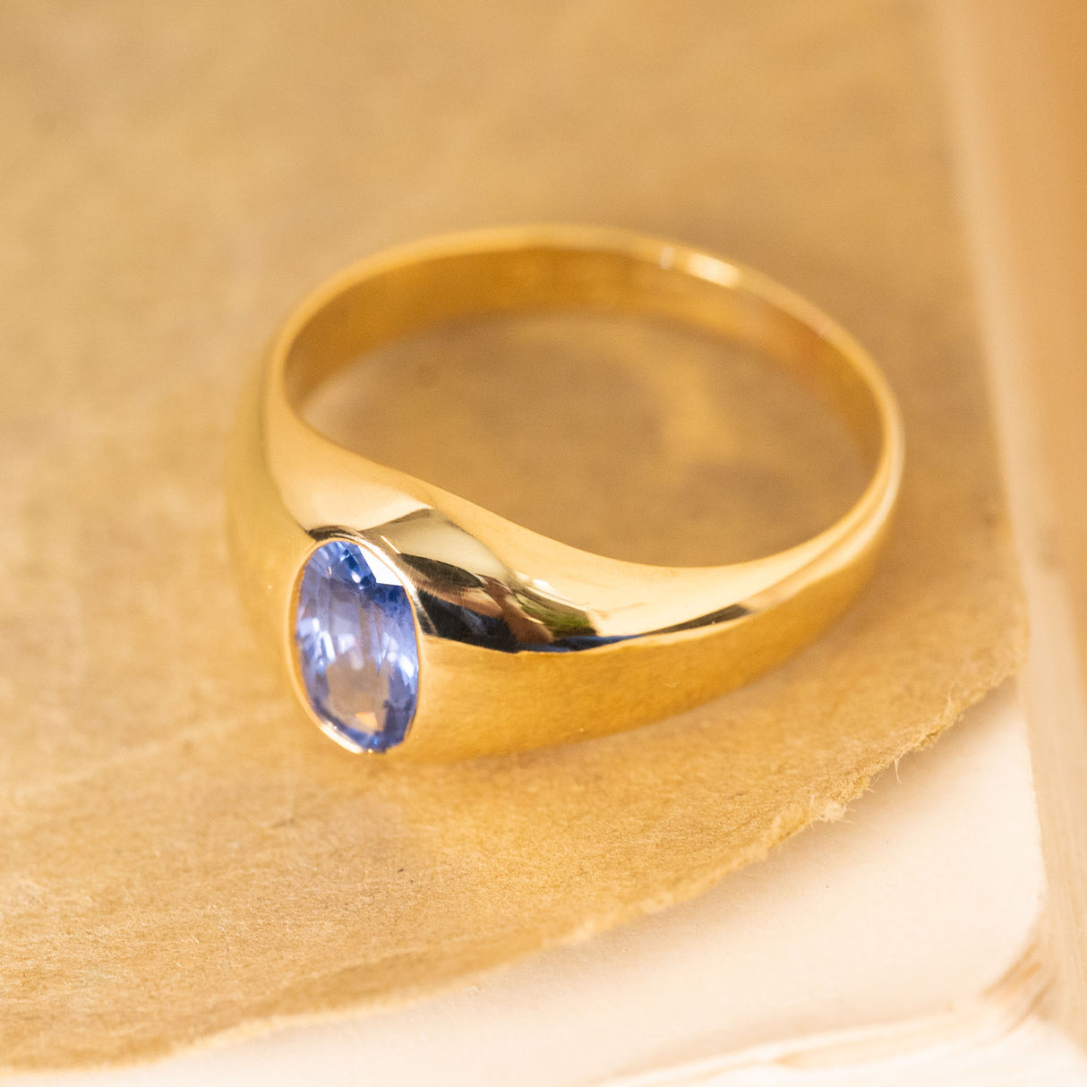 Edwardian sapphire gypsy ring showcasing a luminous iris-blue sapphire set into a polished gold mount.