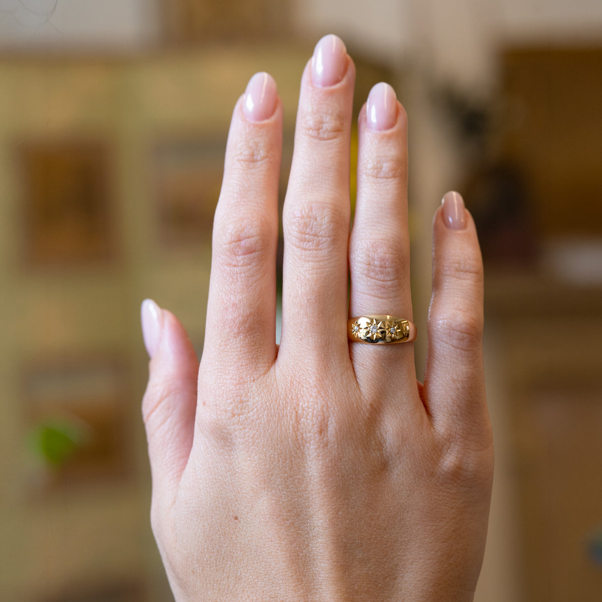 Antique Edwardian three-stone diamond gypsy ring worn on hand.