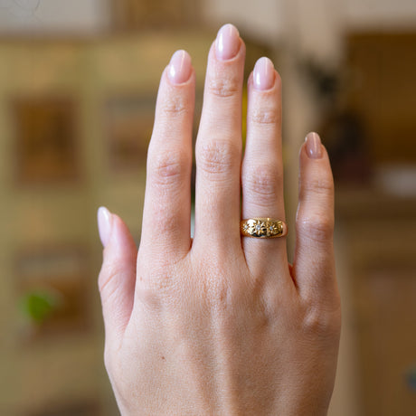 Antique Edwardian three-stone diamond gypsy ring worn on hand.