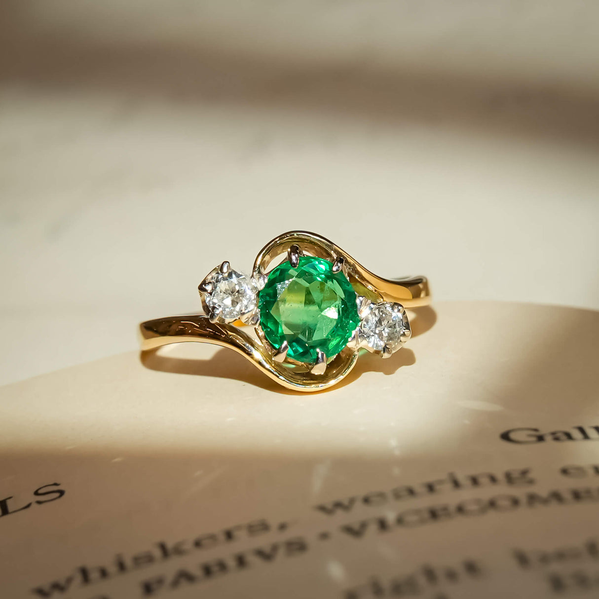 Antique emerald engagement ring with two diamonds in three stone setting