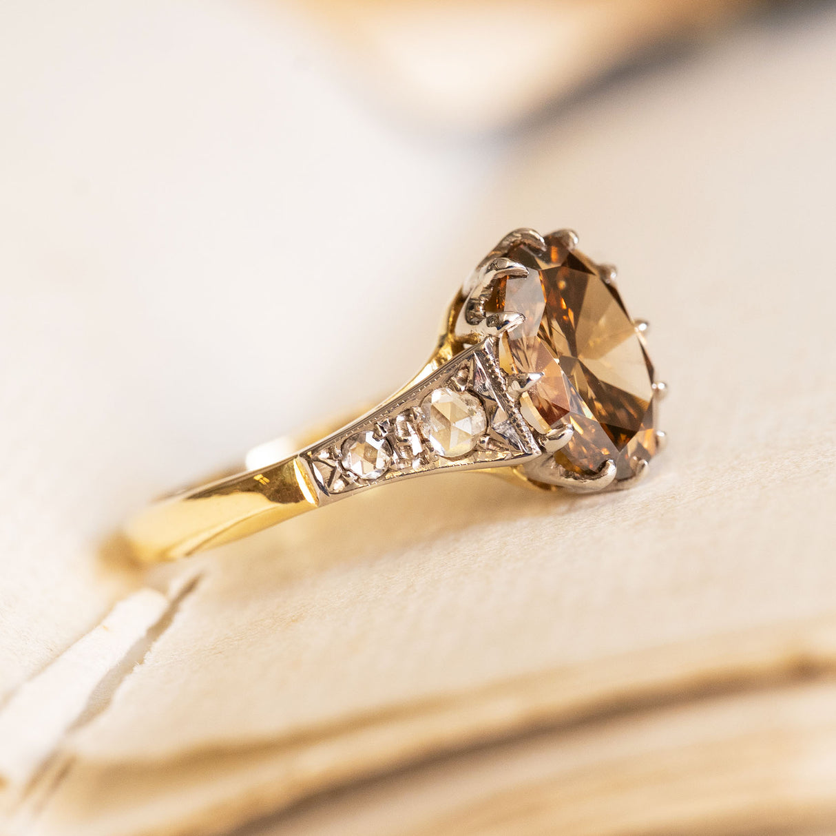 Antique-inspired hazelnut-brown diamond engagement ring with rose-cut diamond accents and decorative openwork gallery.
