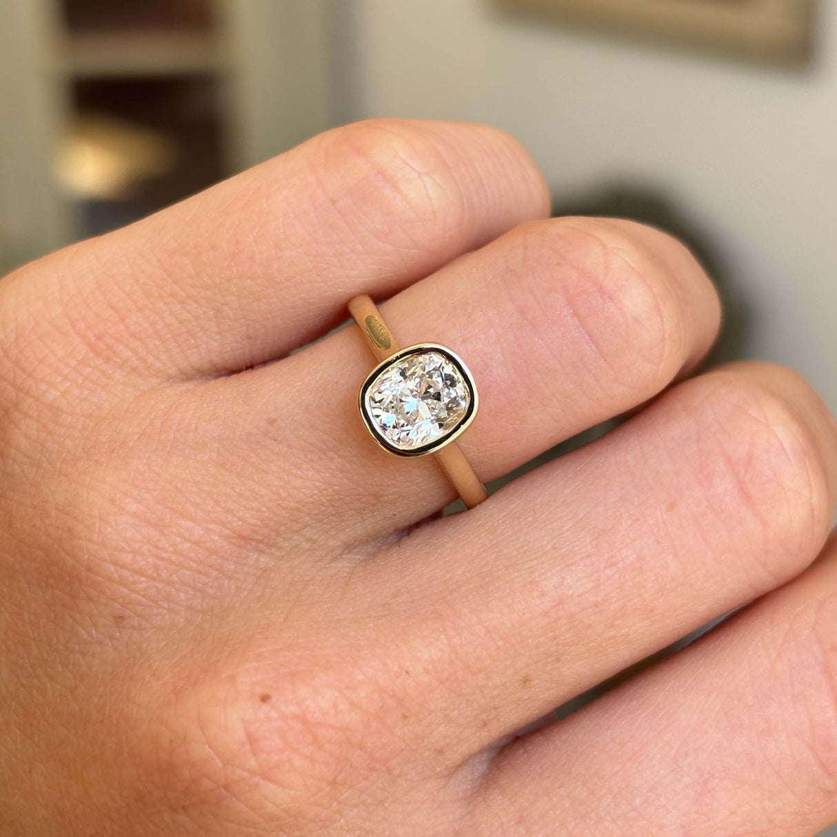 Antique-inspired cushion old-cut diamond solitaire engagement ring with a sparkling cushion old-cut diamond in a refined rub-over yellow gold setting