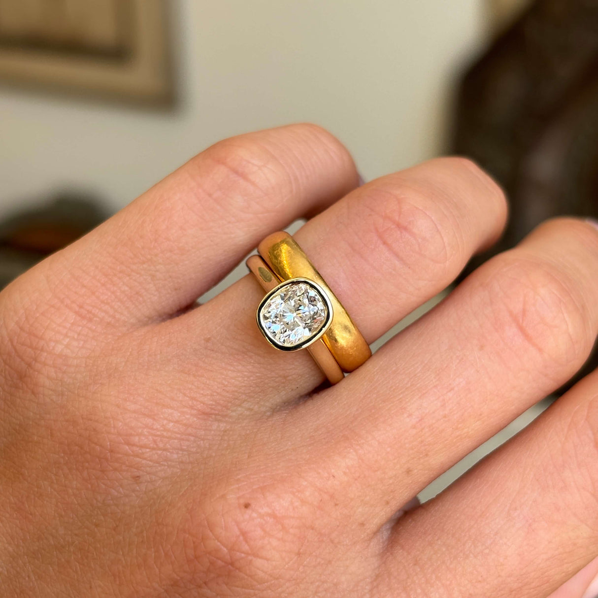 Antique-inspired cushion old-cut diamond solitaire engagement ring highlighting a cushion old-cut diamond and warm yellow gold wedding band
