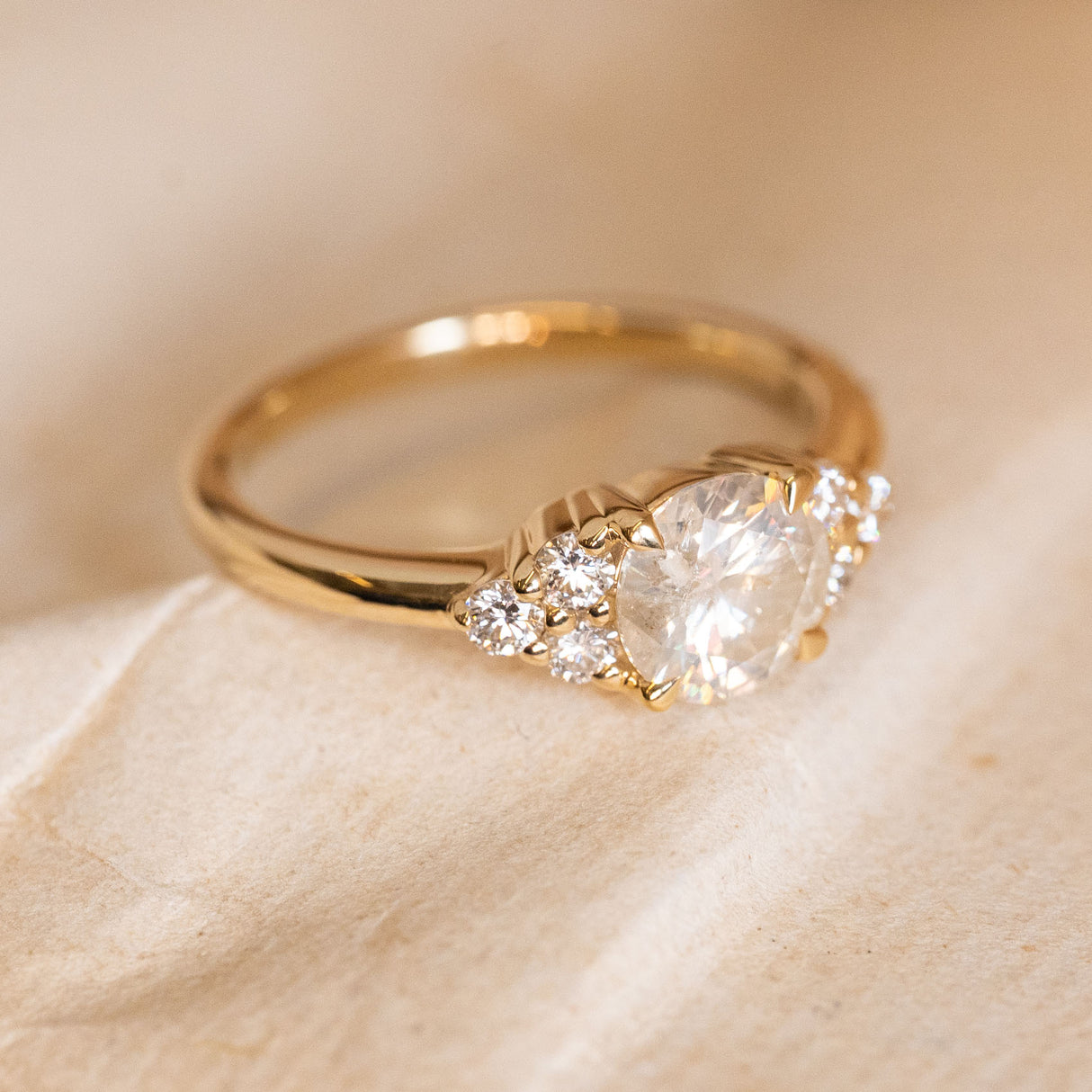 Antique inspired diamond trefoil cluster engagement ring showcasing a round brilliant-cut centre diamond with trefoil diamond shoulder details.