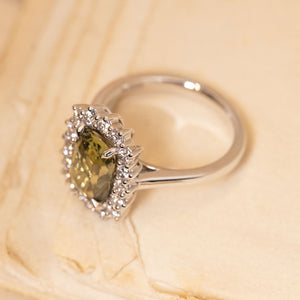 Antique-inspired green sapphire and diamond cluster engagement ring with a cushion-cut green sapphire and diamond halo setting in white gold.