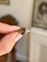 Antique-inspired hazelnut-brown diamond and rose-cut diamond engagement ring showcasing a hazelnut-brown diamond centre stone with rose-cut diamond detailing, held by hand.