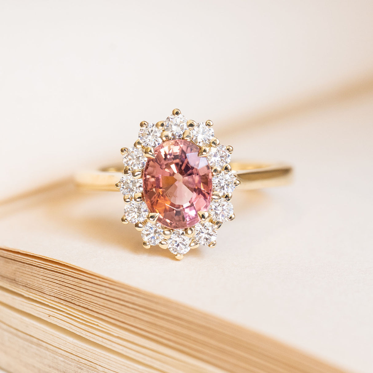 Antique-inspired rose-pink tourmaline and diamond cluster engagement ring in yellow gold.