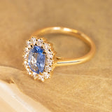 Sky blue sapphire and diamond cluster ring showcasing a luminous elongated sapphire framed by brilliant white diamonds and a refined gold band.