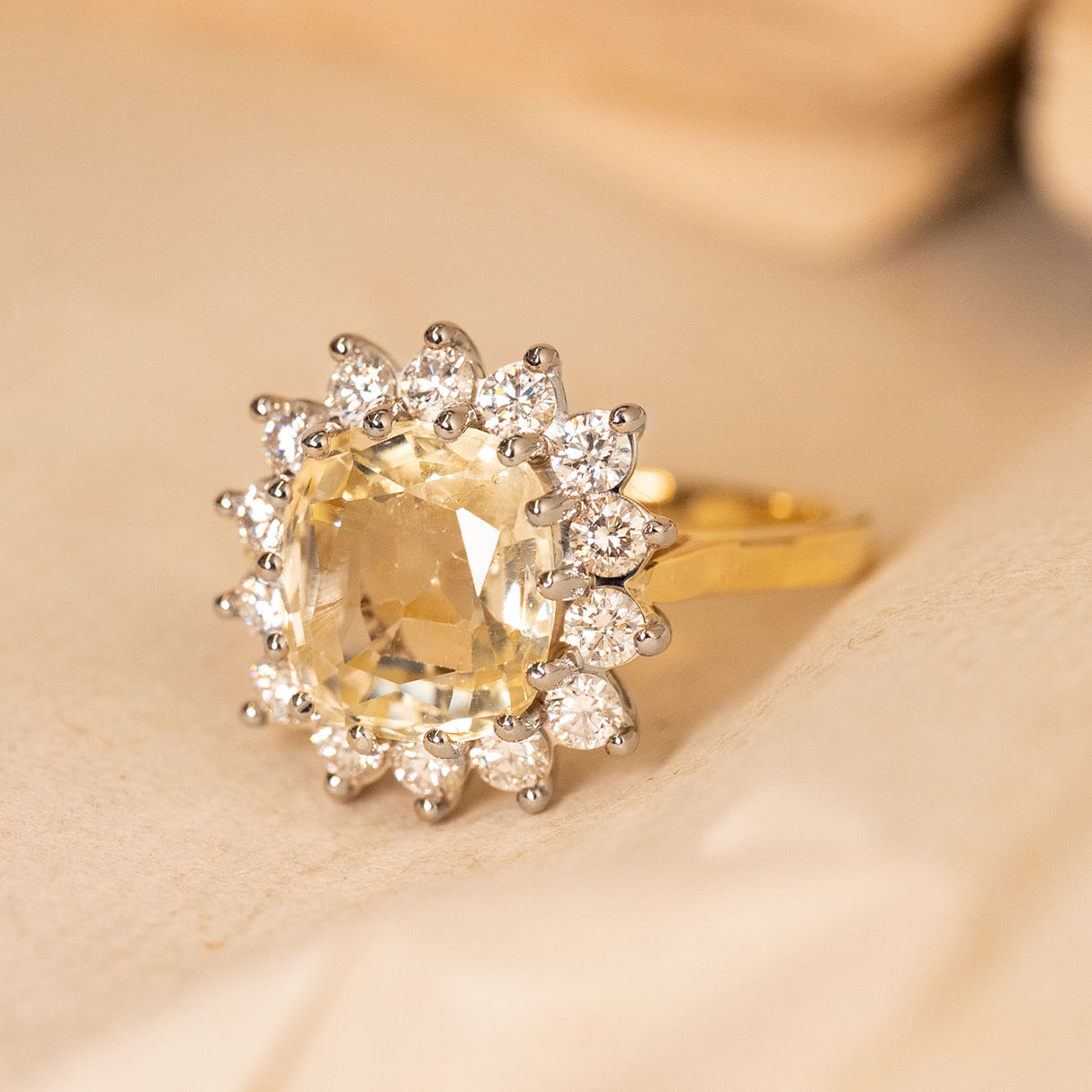 Antique inspired yellow Ceylon sapphire and diamond cluster engagement ring highlighting the oval yellow sapphire and diamond halo setting.