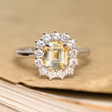 Antique-inspired yellow sapphire and diamond cluster engagement ring featuring a yellow sapphire surrounded by brilliant-cut diamonds.