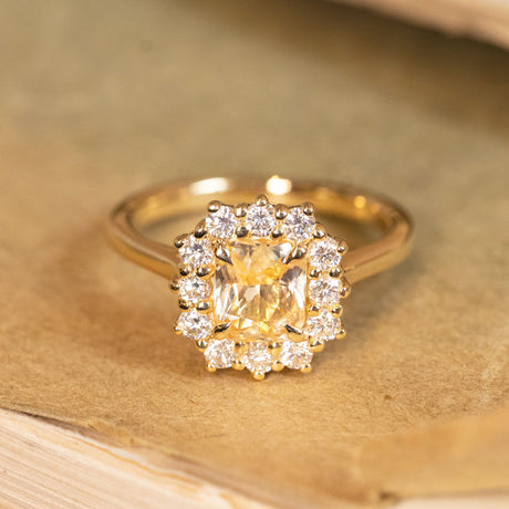 Antique-inspired yellow sapphire and diamond cluster ring showcasing a luminous yellow sapphire framed by sparkling diamonds.