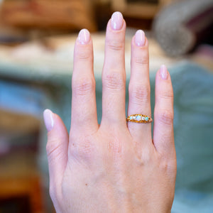 Antique late Victorian opal and diamond five-stone ring worn on hand.