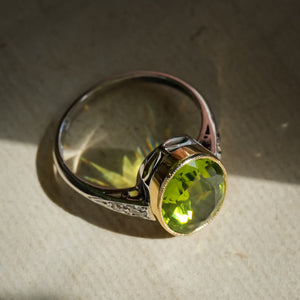 Antique peridot ring with oval green gemstone and diamond set band