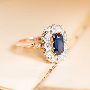 Royal-blue sapphire and diamond cluster ring with a richly coloured sapphire encircled by sparkling old-cut diamonds and delicate gold detailing.