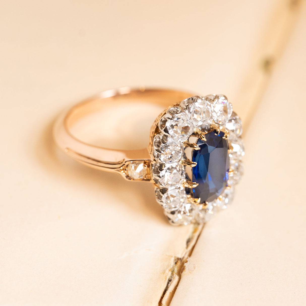 Antique sapphire and diamond cluster ring showcasing a deep royal-blue sapphire framed by bright old-cut diamonds in a classic Jugendstil inspired design.