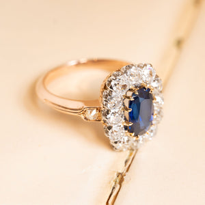 Antique sapphire and diamond cluster ring showcasing a deep royal-blue sapphire framed by bright old-cut diamonds in a classic Jugendstil inspired design.
