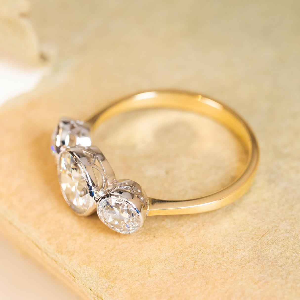 Antique Edwardian old-cut diamond three-stone ring showcasing delicate detailing and an elegant gallery.