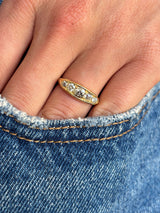 Antique Victorian old-mine cut diamond five-stone engagement ring set with five graduated old-mine cut diamonds, worn on a hand.
