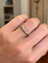 Antique Victorian old-mine diamond five-stone ring featuring five graduated old-mine cut diamonds in a classic carved setting, worn on a hand.