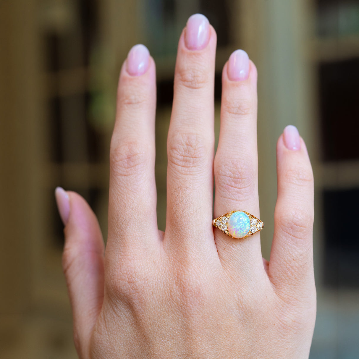 Antique Victorian opal and diamond ring worn on hand.
