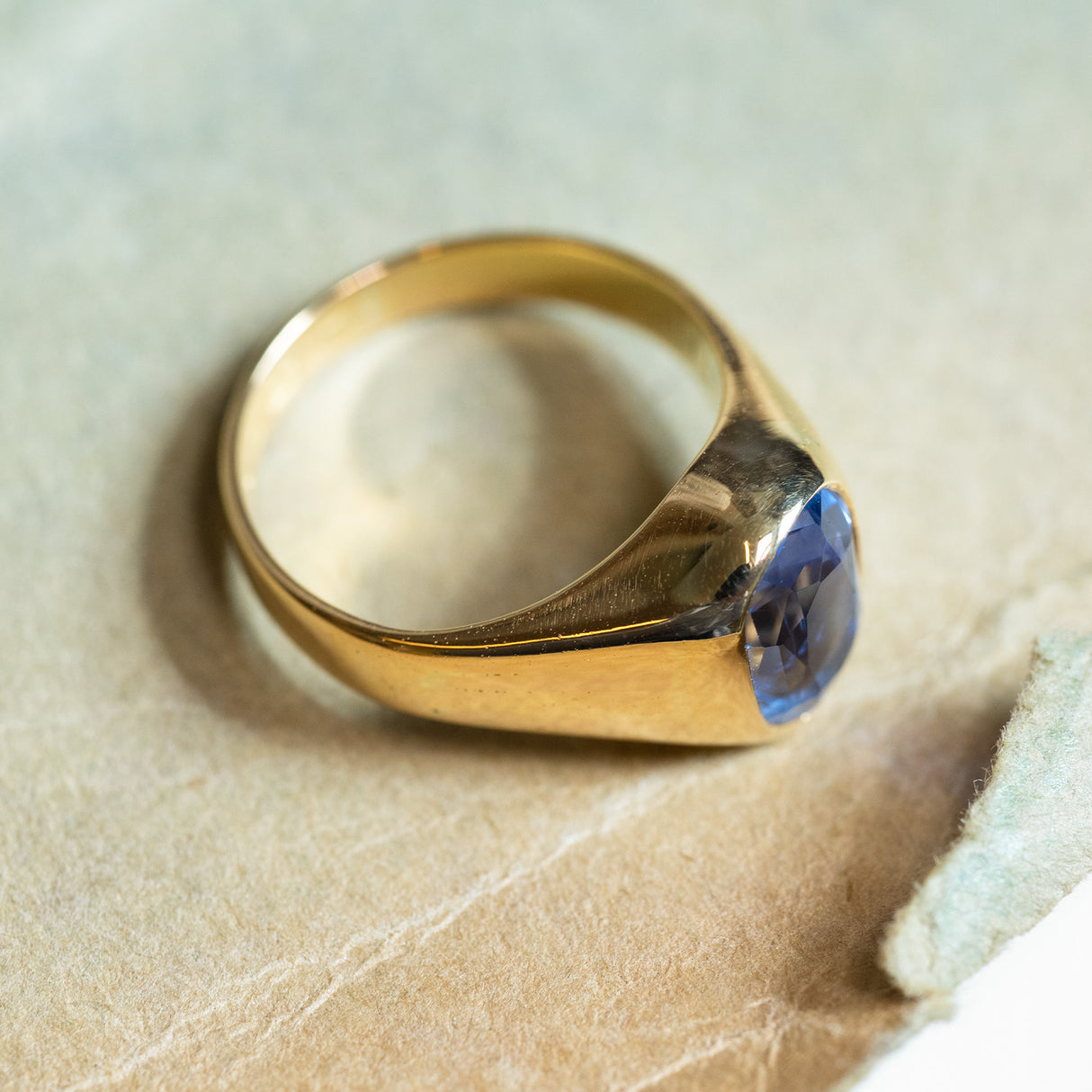 Antique Victorian sapphire single-stone ring with rich blue sapphire and sculpted gold shoulders.
