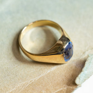 Antique Victorian sapphire single-stone ring with rich blue sapphire and sculpted gold shoulders.