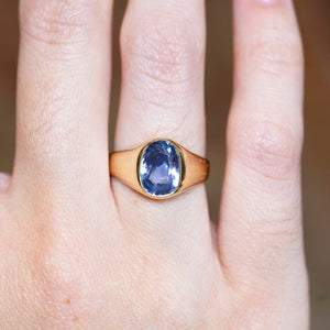 Antique Victorian sapphire single-stone ring with oval blue sapphire shown on finger.