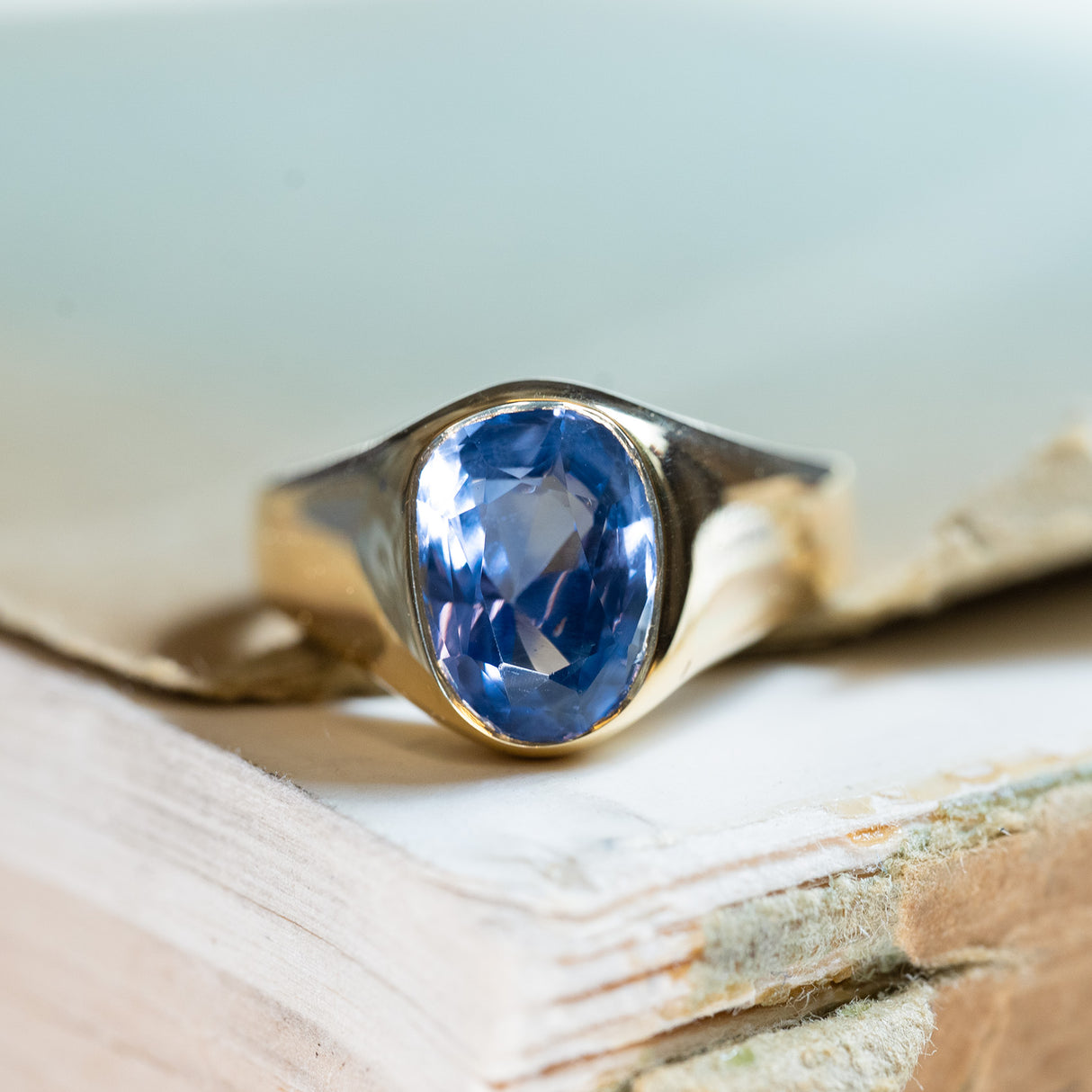 Antique Victorian sapphire single-stone ring with oval blue sapphire in polished gold setting.