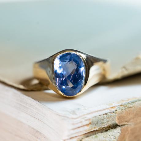 Antique Victorian sapphire single-stone ring with oval blue sapphire in polished gold setting.