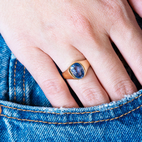 Antique Victorian sapphire single-stone ring worn on hand resting in denim pocket.