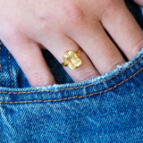 Antique Victorian yellow sapphire solitaire ring worn with hand resting in denim pocket.